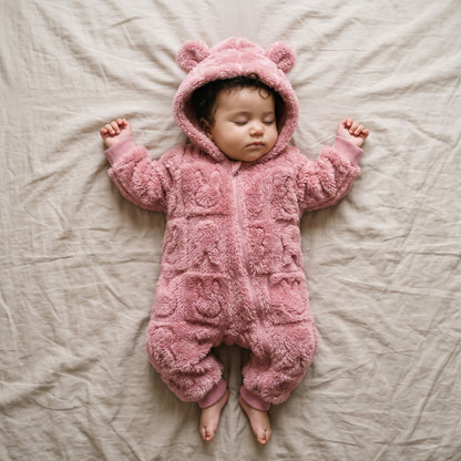 Bébé endormi dans une combinaison bébé polaire doublée sherpa rose à capuche ourson