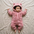 Bébé endormi dans une combinaison bébé polaire doublée sherpa rose à capuche ourson