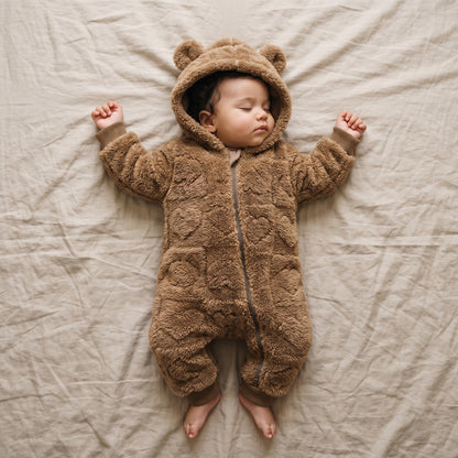 Bébé endormi dans une combinaison bébé polaire doublée sherpa marron à capuche ourson